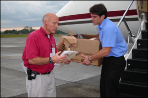 Foto: Los doctores Jacob Wamsley y Eduardo Azziz Baumgartner embarcan los especímenes en el avión de los CDC en Panamá.