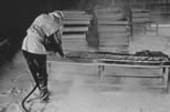 Trabajador que usa un rociador de agua para contener el polvo