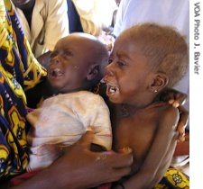 Laure Souley holds her  three-year-old daughter and an infant son