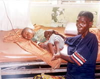 child receiving a blood transfusion and his mother, in a hospital bed  
