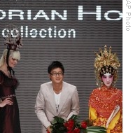 Hong Kong designer Dorian Ho, center, acknowledges the audience as he is flanked by models following a show of his label (File)