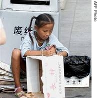 Chinese migrant girl collects old cardboards and other recyclable items beside a dust bin on Tiananmen Square 