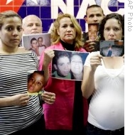 Cuban immigrants hold photos of their children, who remain in Cuba, after a news conference in Miami (File Photo - 18 Nov 2008)