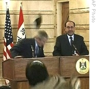 In this image from APTN video, man, throws shoe at US President George W. Bush, left, during news conference with Iraq Prime Minister Nouri al-Maliki, 14 Dec 2008