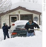 Bob Brazell helps shovel out his daughter Julia's car in Crested Butte, Colo., 26 Dec 2008
