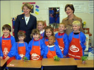 First Lady Laura Bush and Secretary Spellings visit with kindergarten, first, and second graders who participated in a plant-potting project to landscape the new playground at Hancock North Central Elementary School in Kiln, Mississippi.