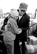 Photo: Music star Bono of the rock group U2 hugs Clinical Center patient Lesley Clementi at an airlift of 83,000 shoe box gifts in New York City.
