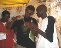 Teddy Malachi (right) and Jamal Ahmed (center) testing water