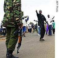 A supporter of Kenya's Opposition leader Raila Odinga taunts a Kenyan policeman during a demonstration in the street of Kisumu, Kenya, 16 Jan 2008