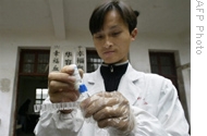 Chinese medic tests samples for Snail Fever, or Schistosomiasis (file photo)