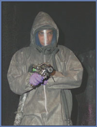 Worker wearing face mask, protective suit and  gloves.