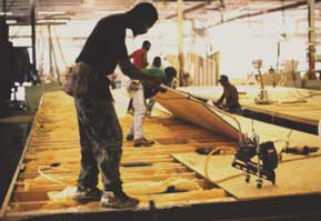 Worker using nail gun with wheels and extension