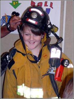POWAY, Calif., Feb. 13, 2008 -- A fourth grader at Painted Rock Elementary School dons firefighter gear during a FEMA for Kids presentation in Poway. photo by John Ashton