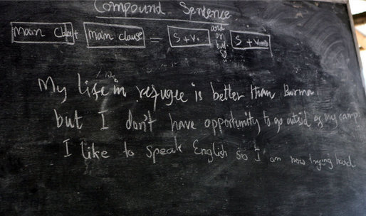 The English lesson on the chalkboard in a grammar class visited by Mrs. Laura Bush in Mae La Refugee Camp tells the story of the Burmese refugees and uses three lines to discuss compound sentence construction. It says " My life in refugee is better than Burma but I don't have opportunity to go outside of my camp. I like to speak English so I am now trying hard.” The Aug. 7, 2008 visit to the camp in Mae Sot, Thailand, highlighted the fact that it has been 20 years since the crackdown in Burma that sent many people fleeing the dire conditions. Many residents have been born in one of the nine camps along the border or have lived most of their lives there. White House photo by Shealah Craighead