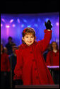 Four-year-old singer Kaitlyn Maher waves to the crowd during her performance Thursday, Dec. 4, 2008, at the Ellipse in Washington, D.C., for the annual Lighting of the National Christmas Tree. White House photo by Eric Draper