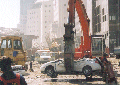 crane moving crushed automobile