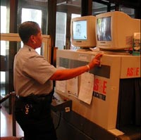 Library Police Officer operates x-ray equipment