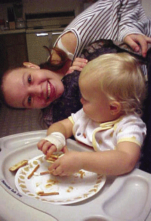 photo of a young woman and a child; the child is in a highchair