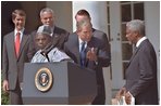 President George W. Bush welcomes UN Secretary General Kofi Annan to the podium after his announcement of Presidential HIV/AIDS Trust Fund Initiative as Nigerian President Olusegun Obsanjo looks on at left in the Rose Garden, Friday, May 11, 2001.