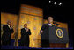 President George W. Bush receives applause during his remarks to The Leon H. Sullivan Foundation Tuesday, Feb. 26, 2008, in Washington, D.C. Joining the President on stage are Ambassador Andy Young, Chairman of the Board, Leon H. Sullivan, background center, and Ambassador Howard Jeter, president and CEO of The Leon H. Sullivan Foundation. White House photo by Eric Draper