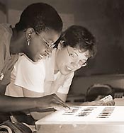 Team members Delia Alexander (left) and Tamara Hemmerlein examine recently-processed slides from their field research during the American Folklife Center’s June 2000 field school in Bloomington, Indiana.