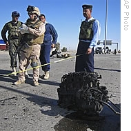 A US marine and Iraqi police investigate a scene of car bombing just outside Fallujah, Iraq, 28 Dec 2008