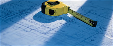 Photo: A tape measure and blue prints