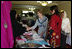 Mrs. Laura Bush greets local businesswomen as she tours the marketplace of the Arzu and Bamiyan Women's Business Association on June 8, 2008 in Afghanistan. The carpets, embroidery and other Afghan wares are all made by women.