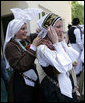 A girl helps her friend tie her head scarf as they wait for President George W. Bush's as he participates in a United States - European Union Working Lunch Tuesday, June 10, 2008, at the Brdo Congress Centre in Kranj, Slovenia. White House photo by Chris Greenberg