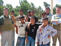 Barber (left) USIP Baghdad Chief of Party Robert Boorda (second from right) and Parker with children in a park reconstructed with U.S. funds in Nasiriya.