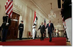President George W. Bush and Iraqi Prime Minister Nouri al-Maliki walk through the Cross Hall to the East Room where the two leaders held a joint press conference Tuesday, July 25, 2006. "You have a strong partner in the United States of America, and I'm honored to stand here with you, Mr. Prime Minister," said President Bush. "It's a remarkable and historical moment, as far as I'm concerned, to welcome the freely elected leader of Iraq to the White House." White House photo by Kimberlee Hewitt