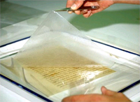Laminating tissue on Washington's first inaugural address is carefully removed by one of the Library's conservation specialists.