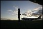 Air Force One sits on the tarmac at Osaka International Airport Wednesday, Nov. 16, 2005, as a military aide salutes the arrival of the President and Mrs. Bush. White House photo by Eric Draper