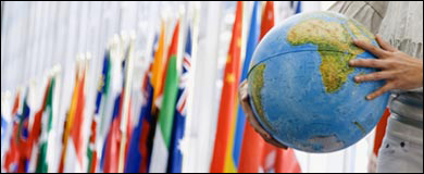 A globe in front of flags of many countries