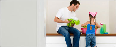 A father and daughter with cleaning supplies