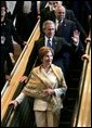 Descending the escalator with Laura Bush and Secretary of State Colin Powell, President George W. Bush waves to the international media after delivering his speech to the United Nations General Assembly in New York City Tuesday, Sept. 21, 2004. White House photo by Eric Draper.