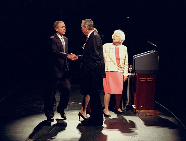 President George W. Bush shakes hands with his father, former president George Bush, as former first lady Barbara Bush looks on from the podium during a Celebration of Reading event Thursday, April 26, in Houston. WHITE HOUSE PHOTO BY PAUL MORSE