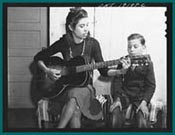 Albuquerque, New Mexico. Spanish-American girl singing folk songs to her little brothers and sisters
