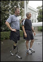President George W. Bush and U.S. Army Staff Sergeant Christian Bagge, 23, of Eugene, Ore., talk with the media after their run on the South Lawn Tuesday, June 27, 2006. White House photo by Eric Draper