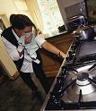 Woman checking for gas leak in cooker