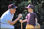 photo of man showing boy a baseball