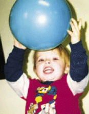 photo of child playing with a big ball