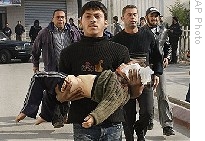 Palestinian medics carry a child injured in Israeli shelling into Kamal Adwan Hospital in Beit Lahiya, northern Gaza Strip, Sunday, 04 Jan. 2009