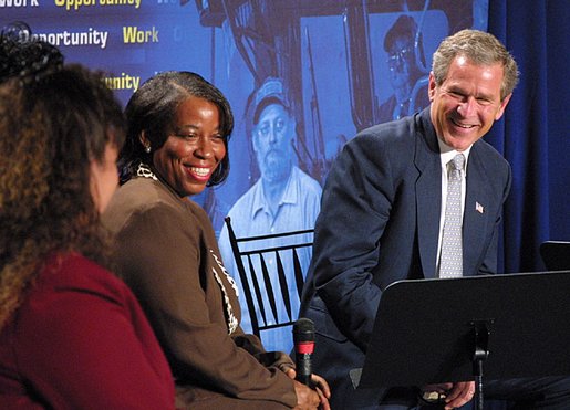 President George W. Bush laughs with participants during a conversation on welfare reform at The Church at Rock Creek in Little Rock, Arkansas on June 3, 2002. White House photo by Eric Draper.