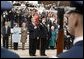 Placing his hand over his heart, President George W. Bush participates in the Wreath Laying Ceremony at the Tomb of the Unknowns in Arlington Cemetery on Veterans Day Nov. 11, 2003. Laura Bush is pictured standing behind the President. White House photo by Paul Morse.