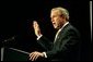 Recalling the experience of watching a Mexican-born Marine take America's oath of citizenship, President George W. Bush raises his right hand as he addresses the National Hispanic Prayer Breakfast in Washington, D.C., Thursday, May 15, 2003. White House photo by Eric Draper