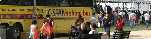 People walking past the C-Span School Bus