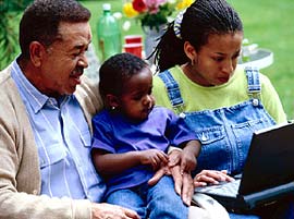 Grandfather with his daughter and her son, all looking at a laptop computer