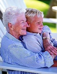 Smiling grandmother sitting with her grandson on her lap.