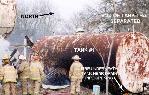 Photo 1: Photograph of Tank #1 prior to explosion, showing the approximate location of the fire under the tank and the end of the tank that exploded.
